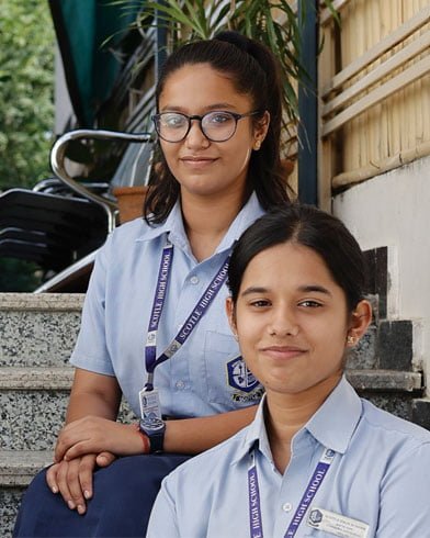 Two girls in school uniforms from the best high school in Jaipur posing for a photo.