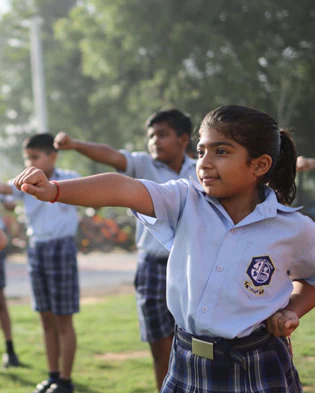 A group of student in school uniforms practicing martial arts at Scotle High School.