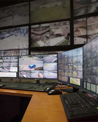 A desk with several monitors and a computer, featuring state-of-the-art security.